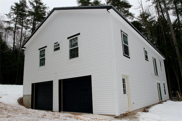 snow covered property featuring a garage