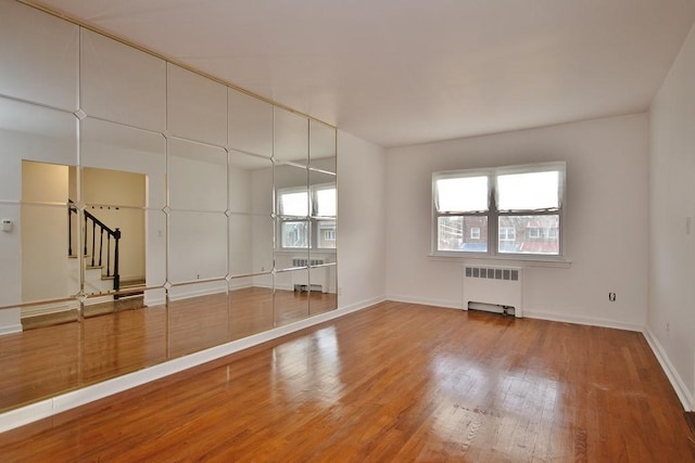 unfurnished room with wood-type flooring and radiator