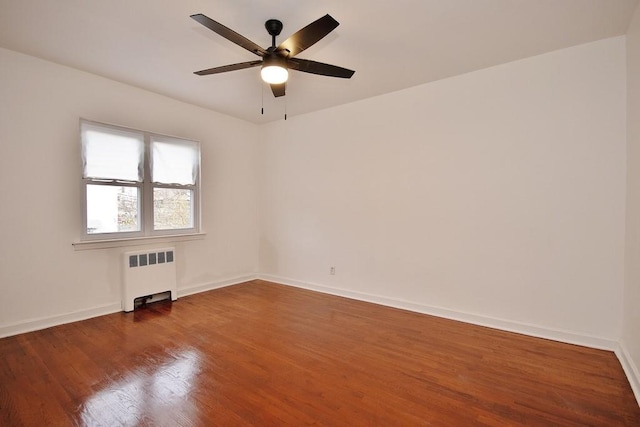 unfurnished room featuring wood-type flooring, radiator, and ceiling fan