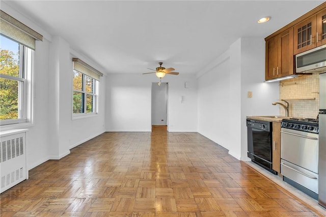 3935 Blackstone Ave Unit 5K, Bronx, NY 10471 - kitchen with dishwasher, range with gas cooktop, stainless steel microwave, radiator heating unit, and ceiling fan