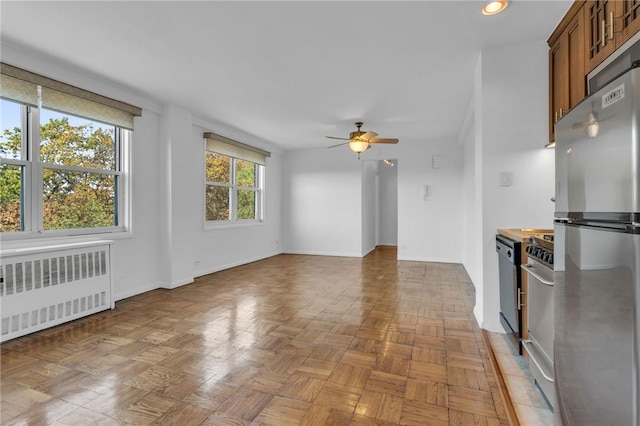 3935 Blackstone Ave Unit 5K, Bronx, NY 10471 - kitchen featuring radiator, freestanding refrigerator, ceiling fan, brown cabinetry, and recessed lighting