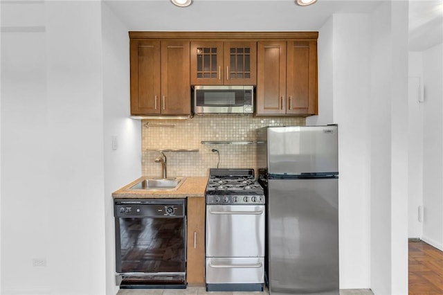3935 Blackstone Ave Unit 5K, Bronx, NY 10471 - kitchen with stainless steel appliances, a sink, backsplash, brown cabinetry, and recessed lighting