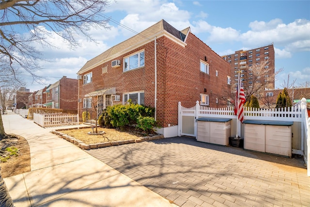 view of property exterior with brick siding and fence