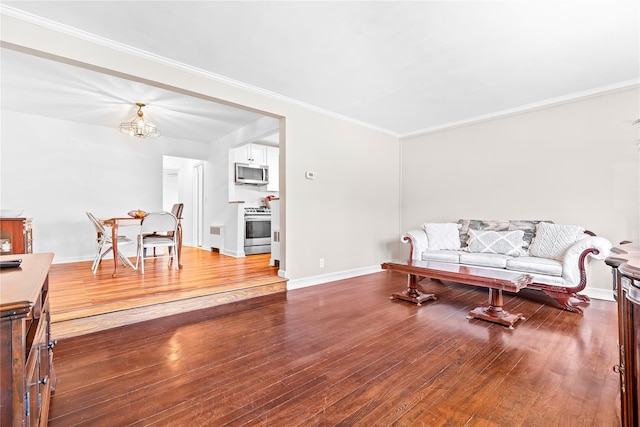 living area featuring ornamental molding, an inviting chandelier, wood finished floors, and baseboards