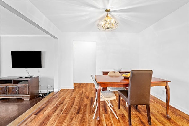 dining room featuring crown molding, a notable chandelier, baseboards, and wood finished floors