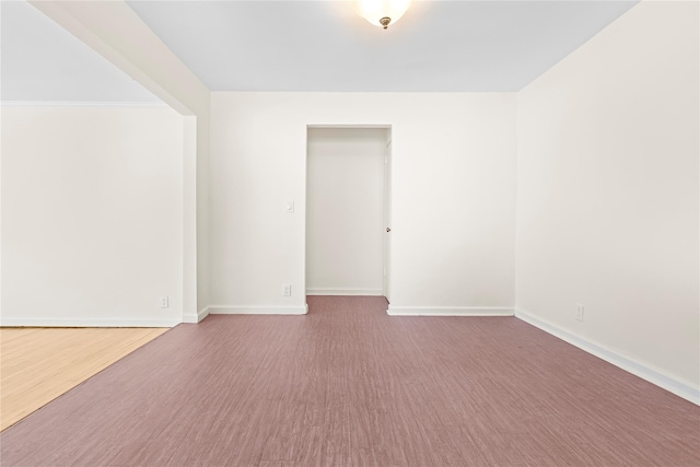 empty room featuring wood finished floors and baseboards