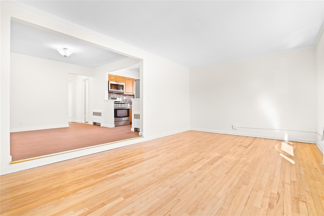 unfurnished living room with light wood-type flooring and baseboards