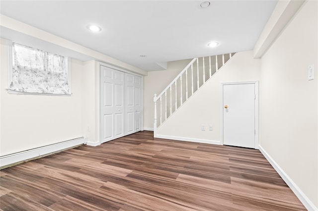 below grade area featuring stairs, a baseboard heating unit, wood finished floors, and recessed lighting