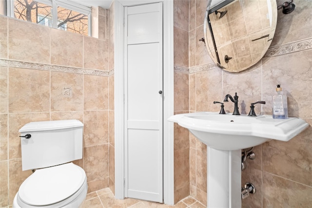 bathroom with tile walls and toilet