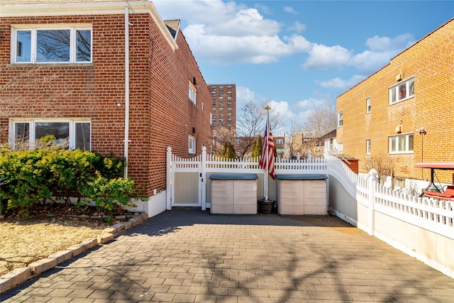 view of home's exterior featuring brick siding and fence