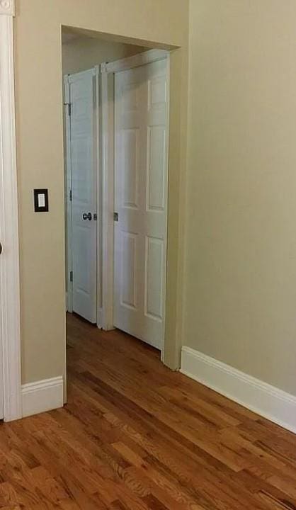 hallway with hardwood / wood-style flooring