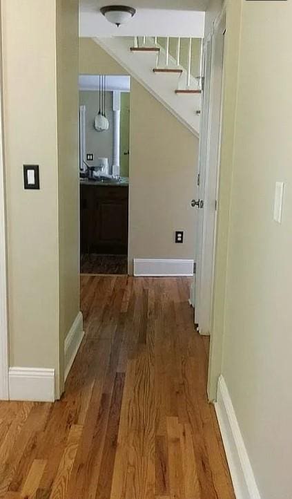 corridor with hardwood / wood-style flooring