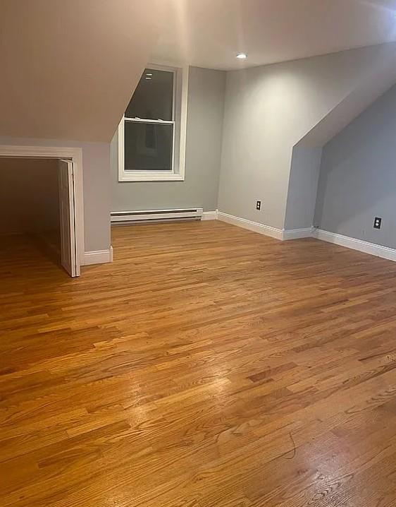 bonus room featuring light hardwood / wood-style floors and baseboard heating