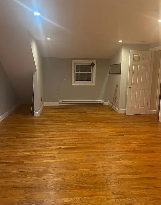 bonus room with light hardwood / wood-style flooring and a baseboard radiator