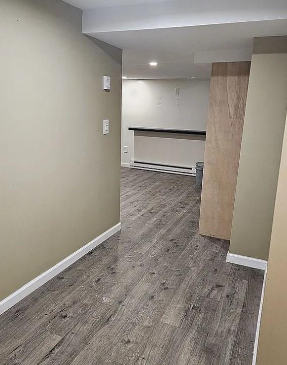 interior space with dark hardwood / wood-style floors and baseboard heating