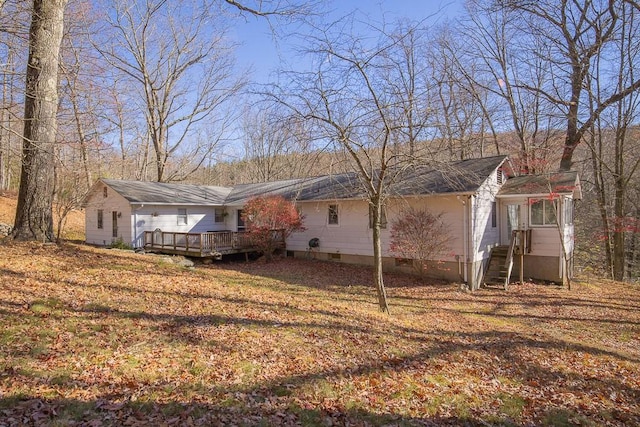 rear view of property featuring a wooden deck