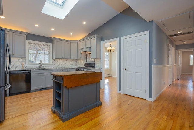 kitchen featuring gray cabinetry, dishwasher, stove, light hardwood / wood-style floors, and custom range hood