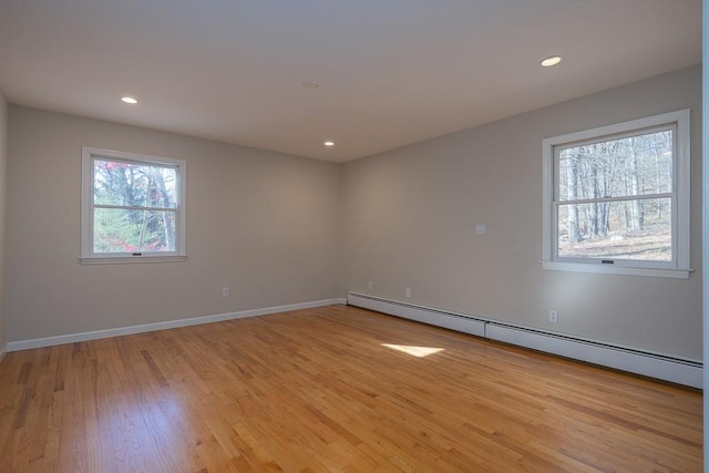 spare room featuring light wood-type flooring and a baseboard heating unit