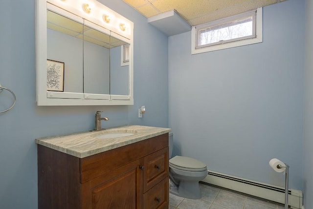 bathroom with tile patterned flooring, vanity, toilet, and a baseboard heating unit