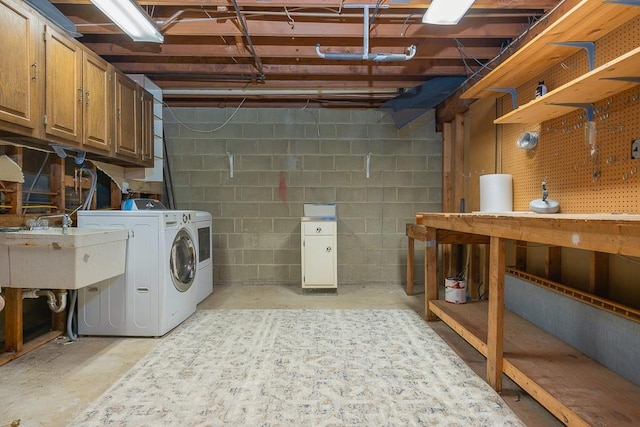 laundry area featuring a workshop area, cabinets, separate washer and dryer, and sink