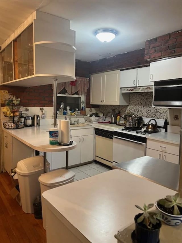 kitchen featuring tasteful backsplash, white cabinetry, and wood-type flooring