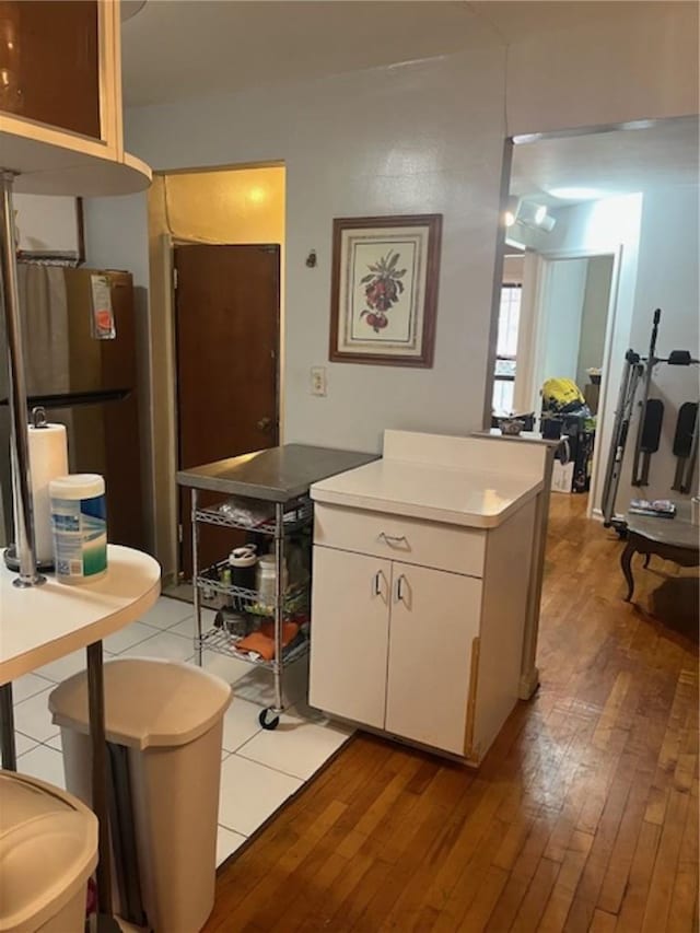 kitchen with decorative backsplash, tile patterned floors, and white cabinetry