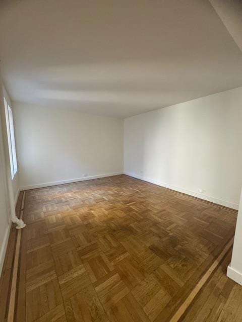 unfurnished room featuring dark parquet flooring