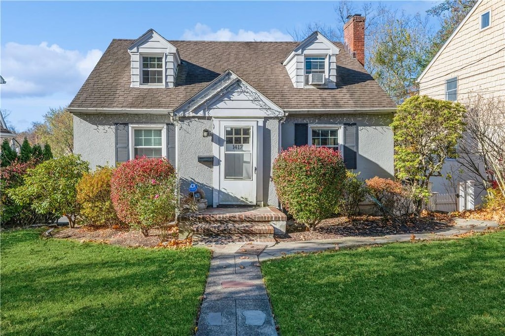 cape cod-style house with a front yard