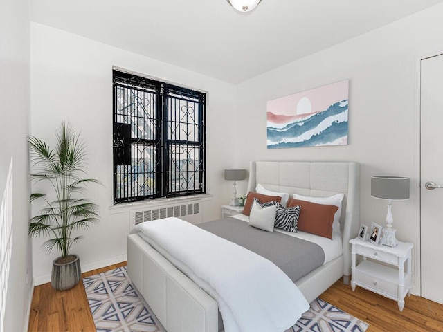 bedroom with radiator and light hardwood / wood-style floors