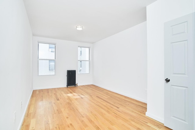 unfurnished room with light wood-type flooring and radiator