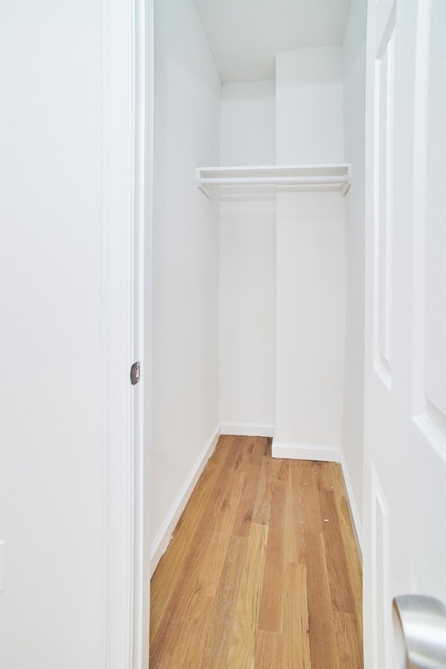 walk in closet with light hardwood / wood-style flooring