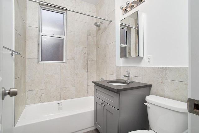 full bathroom with vanity, tiled shower / bath combo, tile walls, and toilet