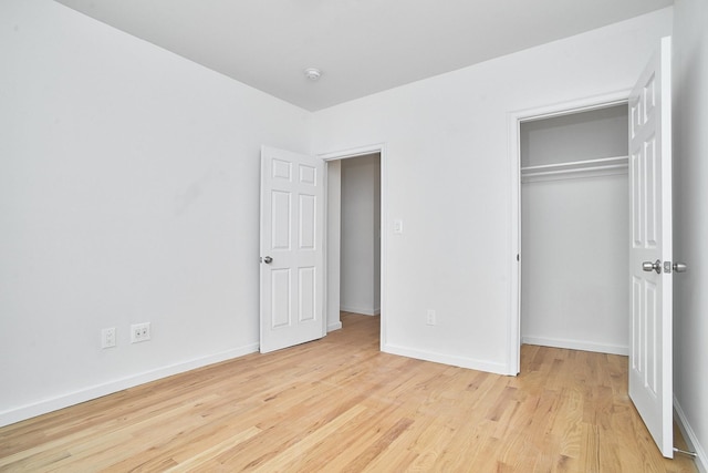 unfurnished bedroom featuring light wood-type flooring and a closet