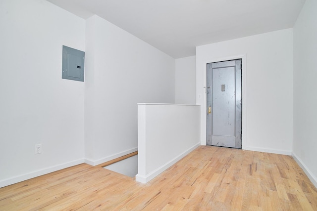 empty room with light wood-type flooring and electric panel