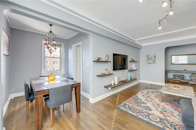 dining space with hardwood / wood-style floors, a wealth of natural light, and crown molding