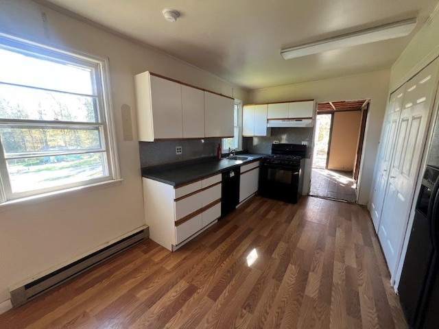 kitchen with sink, a baseboard heating unit, decorative backsplash, white cabinets, and black appliances