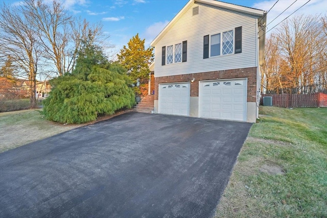 view of property exterior featuring a garage, a yard, and central air condition unit