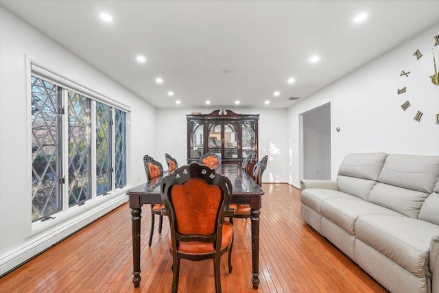 dining space featuring light wood-type flooring and a baseboard radiator