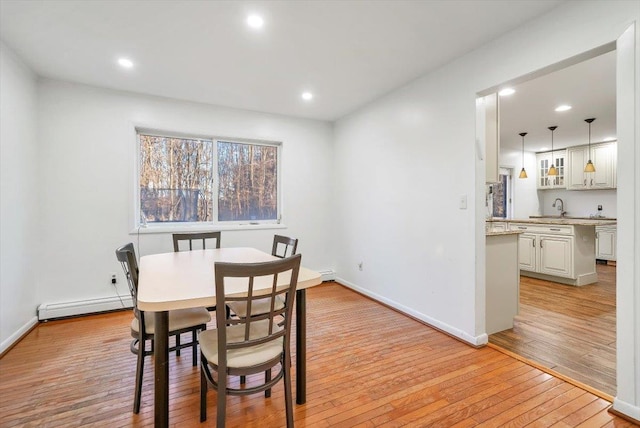 dining room with light wood-type flooring and baseboard heating