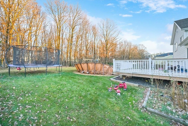 view of yard featuring a deck and a trampoline