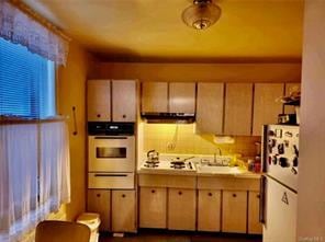 kitchen with sink, oven, and white refrigerator