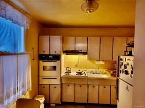 836 Tilden St Unit 6K, Bronx, NY 10467 - kitchen featuring oven, freestanding refrigerator, light countertops, a warming drawer, and stovetop