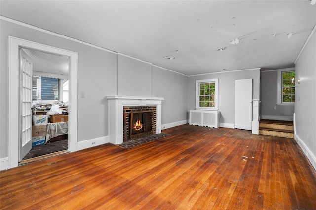 unfurnished living room with crown molding, a fireplace, wood-type flooring, and radiator