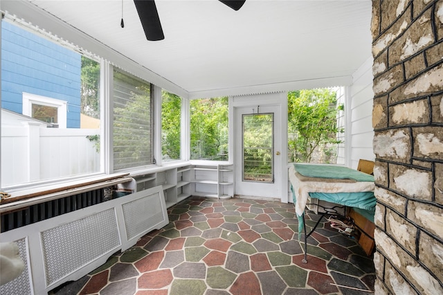 unfurnished sunroom featuring radiator and plenty of natural light