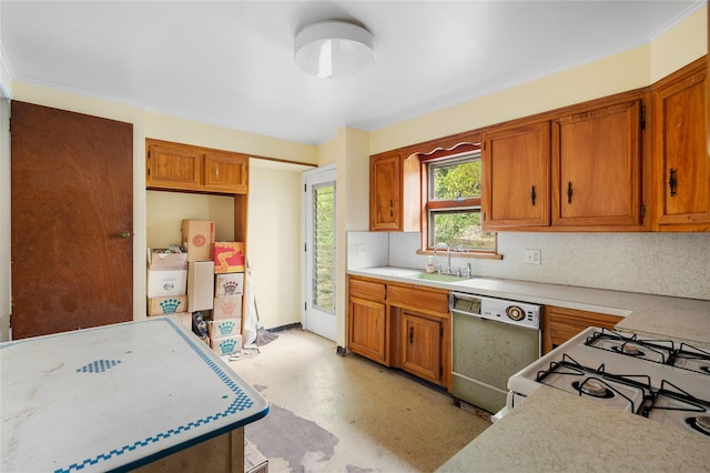 kitchen featuring dishwasher, light countertops, a sink, and brown cabinets