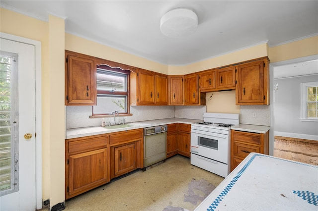 kitchen with light countertops, dishwasher, white range with gas cooktop, and a sink