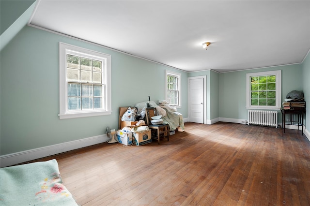 sitting room with radiator, plenty of natural light, baseboards, and hardwood / wood-style floors