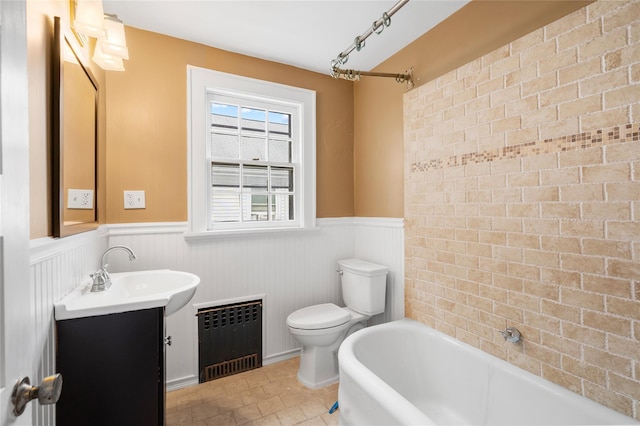 full bath with wainscoting, radiator, toilet, tile patterned floors, and vanity