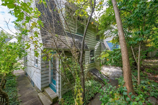 view of property exterior with roof with shingles