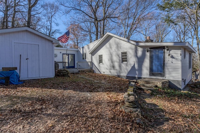 back of house featuring a storage shed